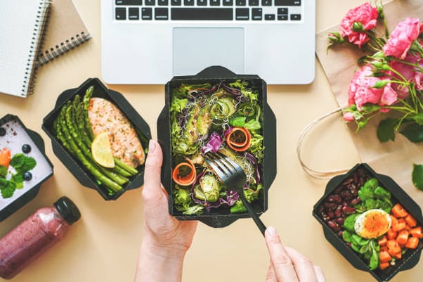 las-manos-femeninas-sostienen-la-caja-de-entrega-de-alimentos-almorzando-en-el-trabajo-desde